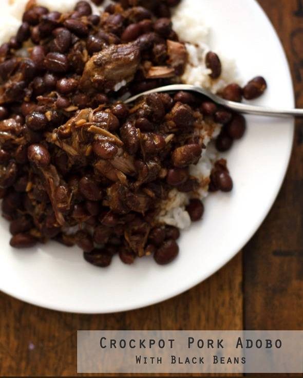 Pork adobo with black beans and rice on a white plate.