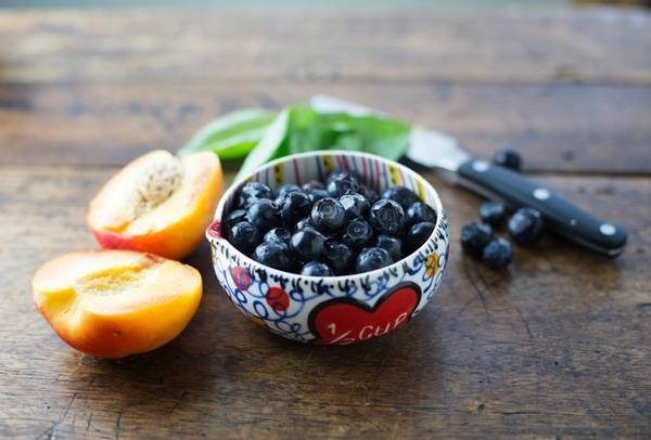Bowl of blueberries next to nectarines.