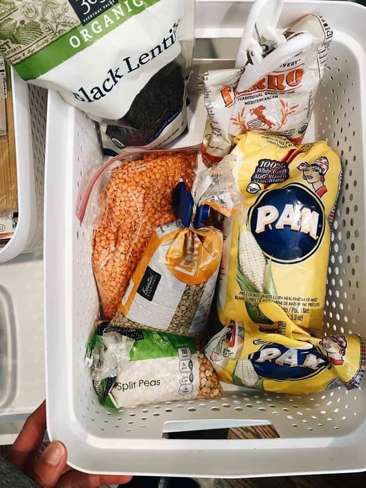 A tub full of packets of corn, lentils, peas and other food items.