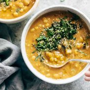 Corn chowder in a bowl with herbs on top.