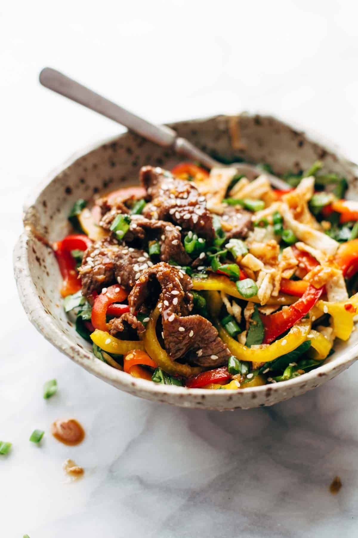 Korean BBQ Steak Bowls! Featuring Korean BBQ steak, bell peppers, scallions, greens, wonton strips, a spicy sesame ginger dressing. | pinchofyum.com Korean BBQ Steak Bowls! Featuring Korean BBQ steak, bell peppers, scallions, greens, wonton strips, a spicy sesame ginger dressing. | pinchofyum.com
