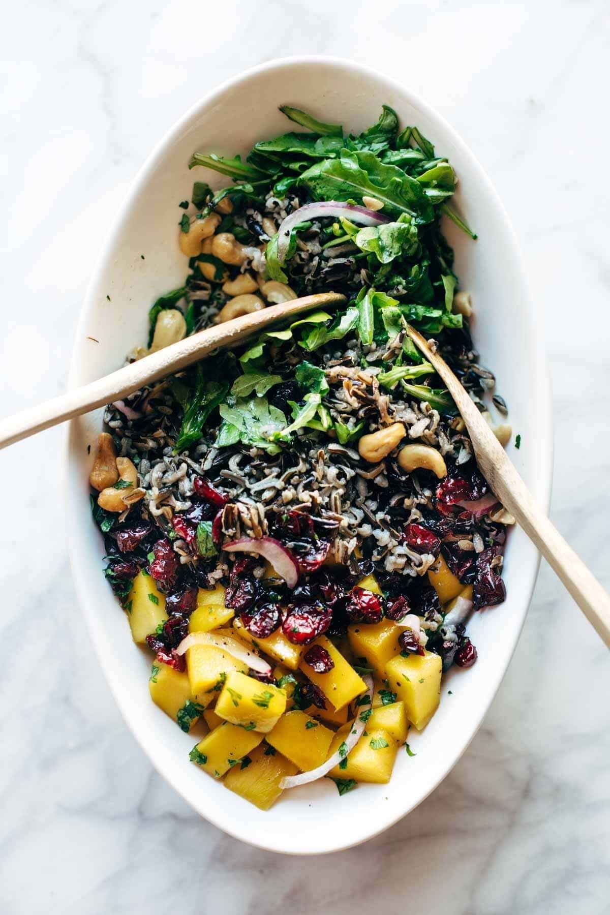 Easy Thanksgiving Salad - arugula, wild rice, cashews, dried cranberries, red onions, and a lemon dressing that shakes up easily in a jar. | pinchofyum.com