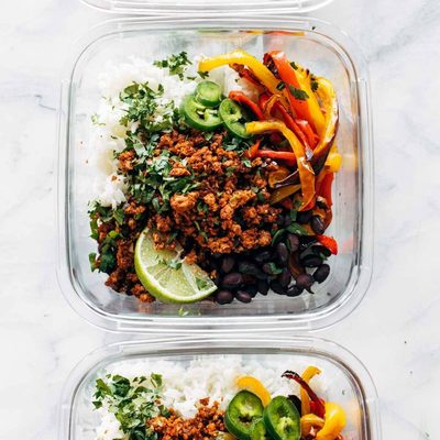 Vegan burrito bowls with rice in glass containers.