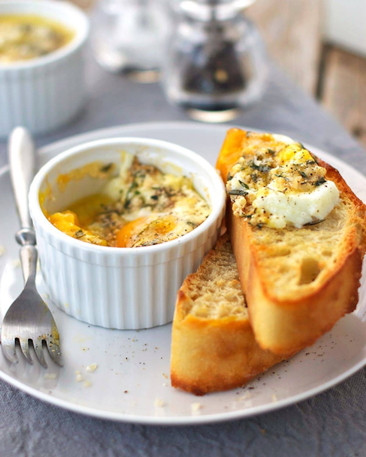 Parmesan baked eggs in a dish with bread.