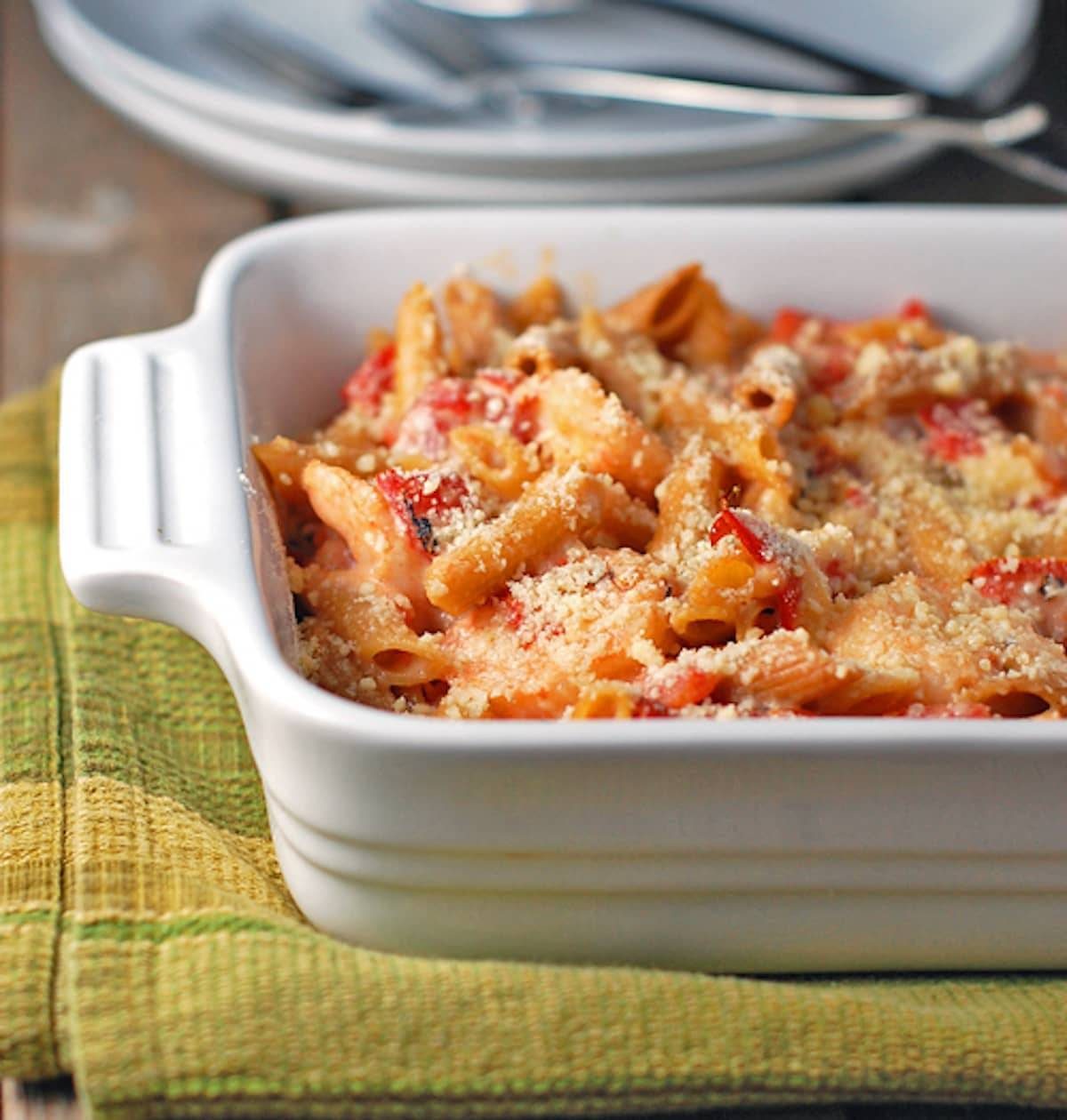 Garlic shrimp baked penne in a white baking dish on a green napkin.