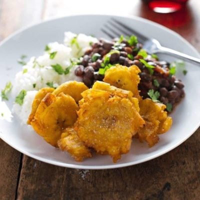 A picture of Garlic Tostones: Puerto Rican Fried Plantains with Rice and Beans