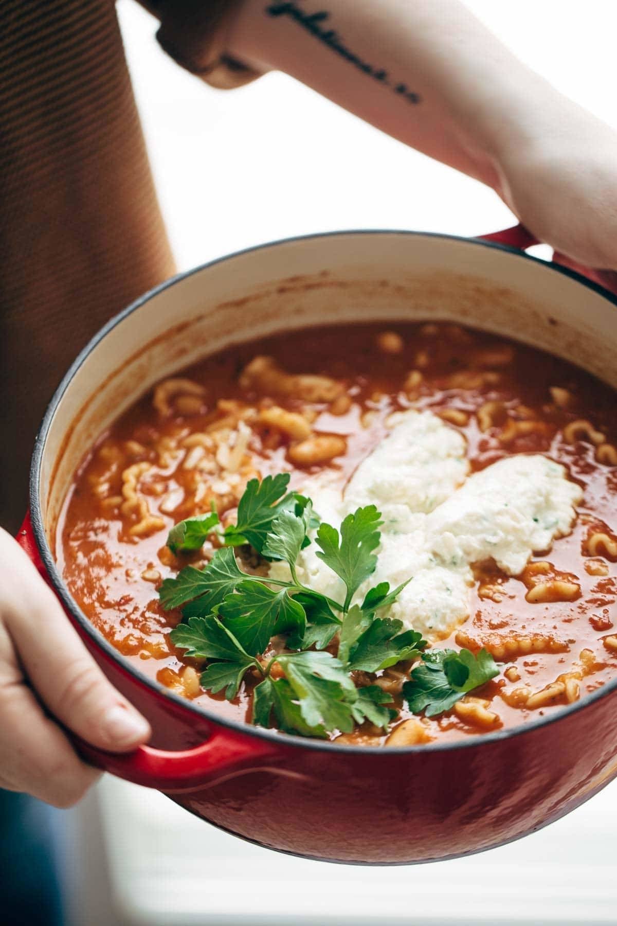 Roasted Garlic and White Bean Lasagna Soup in a red dutch oven with cilantro.